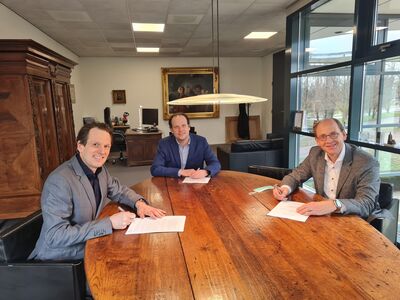 Three people signing paper