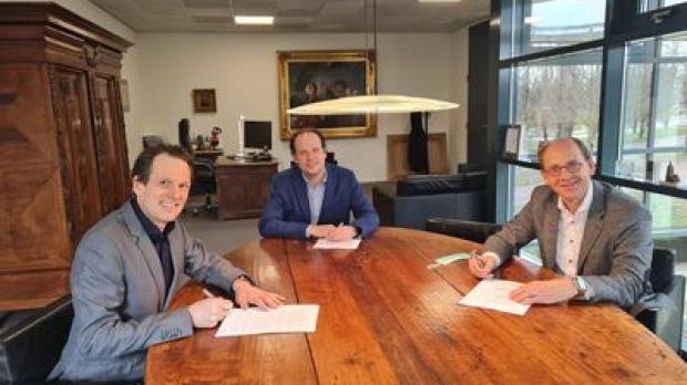 Three people signing paper