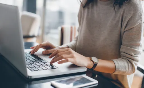 woman sitting as laptop typing on keypad